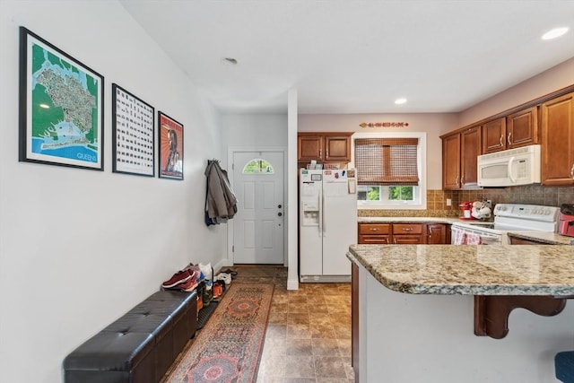 49 Camden St Unit 49, South Hadley, MA 01075 - kitchen featuring white appliances, a breakfast bar area, backsplash, a peninsula, and recessed lighting