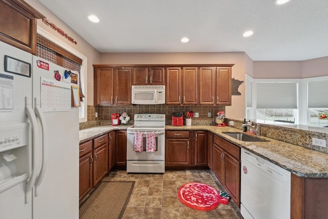 49 Camden St Unit 49, South Hadley, MA 01075 - kitchen with white appliances, a sink, decorative backsplash, light stone countertops, and a peninsula