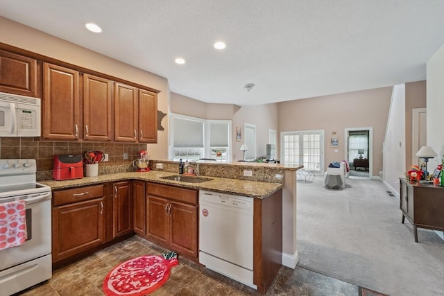 49 Camden St Unit 49, South Hadley, MA 01075 - kitchen featuring white appliances, a peninsula, brown cabinets, light stone countertops, and a sink