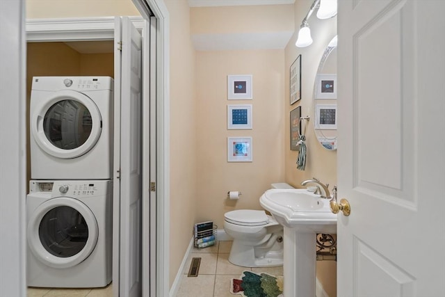 49 Camden St Unit 49, South Hadley, MA 01075 - bathroom with stacked washer / drying machine, tile patterned flooring, toilet, baseboards, and a sink