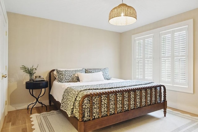 bedroom featuring wood finished floors and baseboards