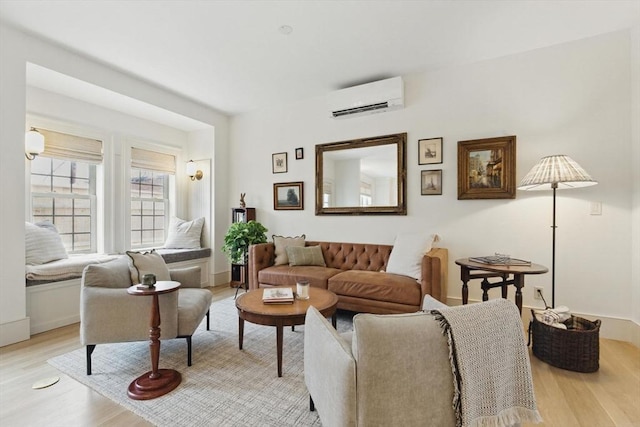 living room with light wood-type flooring, baseboards, and a wall mounted AC