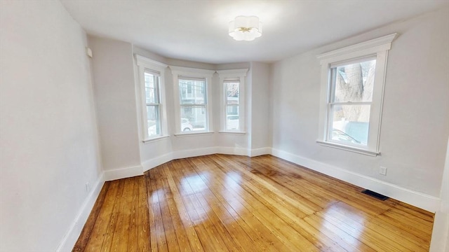 unfurnished room with hardwood / wood-style flooring