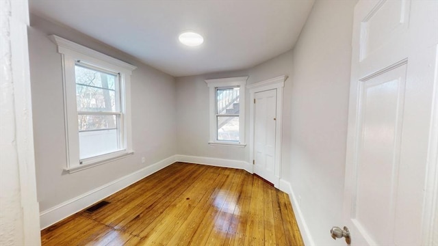 unfurnished room featuring hardwood / wood-style floors and plenty of natural light