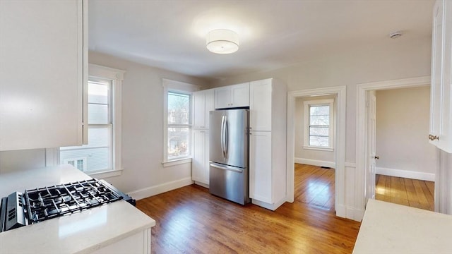 kitchen featuring white cabinetry, stainless steel fridge, and hardwood / wood-style floors