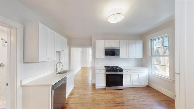 kitchen featuring white cabinets, sink, decorative backsplash, appliances with stainless steel finishes, and plenty of natural light