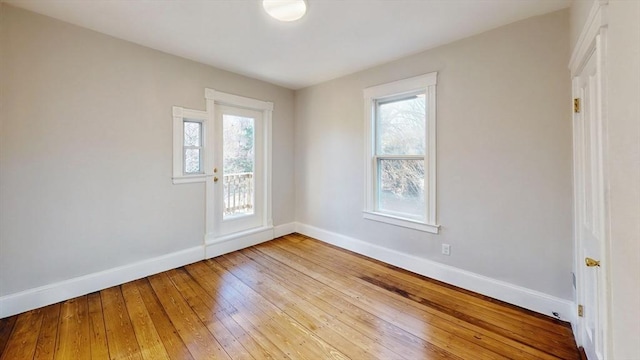 empty room featuring a wealth of natural light and wood-type flooring