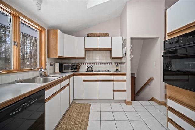 kitchen featuring black appliances, white cabinetry, light countertops, and a sink