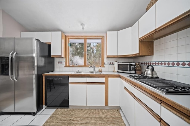 kitchen featuring a sink, white cabinetry, light countertops, appliances with stainless steel finishes, and decorative backsplash