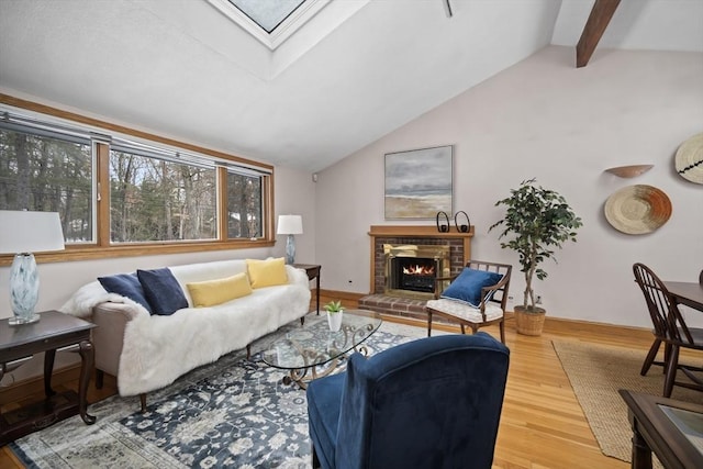 living area featuring lofted ceiling with skylight, a brick fireplace, and wood finished floors