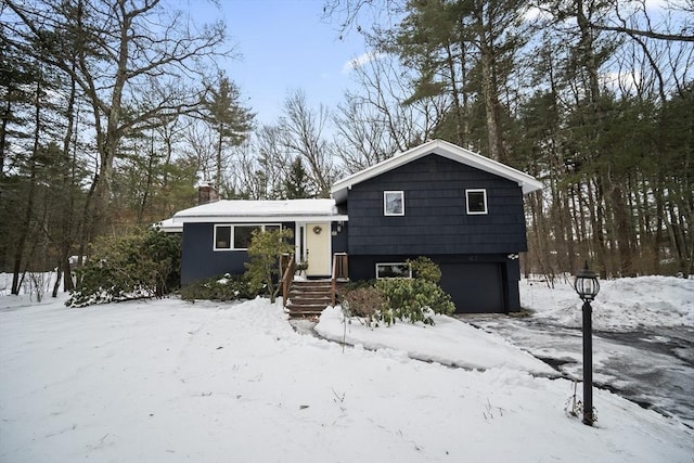 tri-level home featuring a garage and a chimney