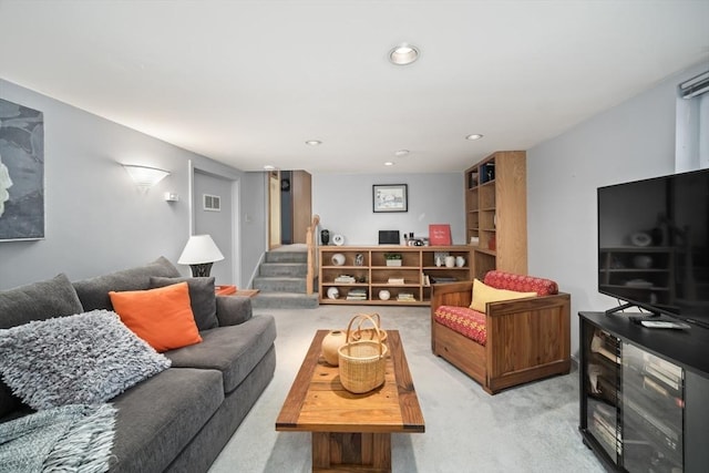 living room featuring recessed lighting, visible vents, light carpet, and stairway