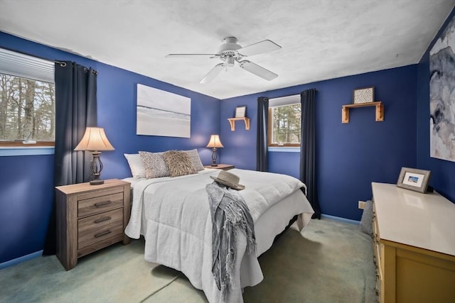 bedroom featuring light carpet, a ceiling fan, and baseboards