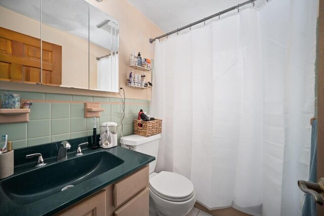 bathroom featuring toilet, backsplash, and vanity