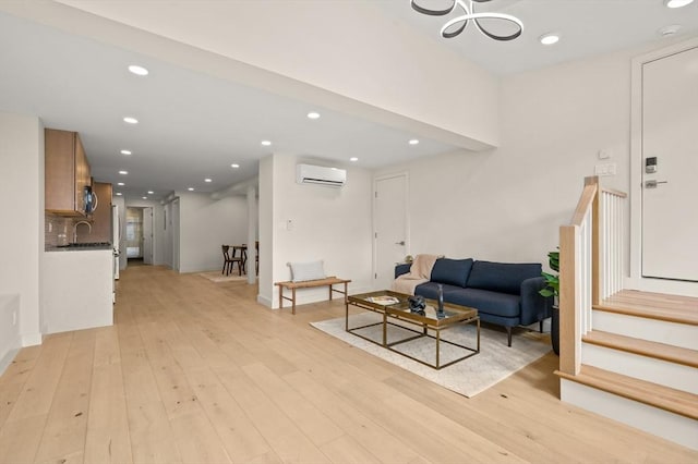 living room with recessed lighting, an AC wall unit, stairway, and light wood finished floors