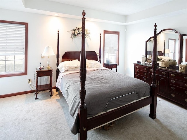 bedroom with baseboards and light colored carpet