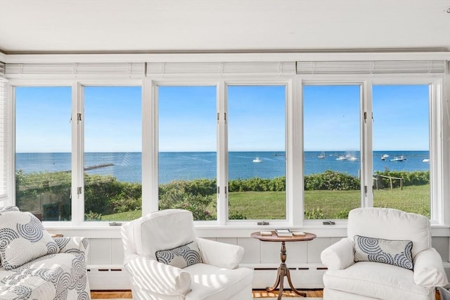 sunroom / solarium featuring a baseboard radiator, a water view, and baseboard heating