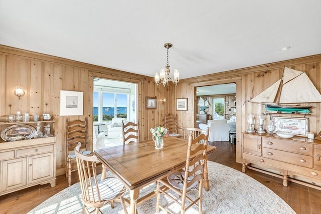 dining room featuring wood finished floors, a wealth of natural light, and an inviting chandelier