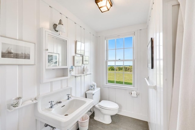 bathroom featuring baseboards, a sink, and toilet