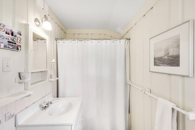 bathroom with vaulted ceiling, vanity, and a shower with shower curtain