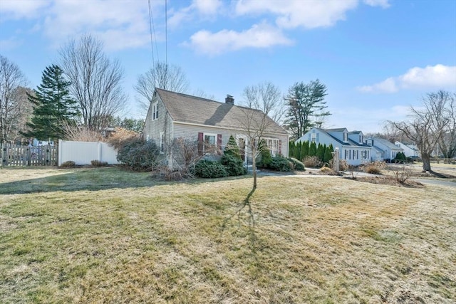 view of front of home with a front lawn, fence, and a chimney