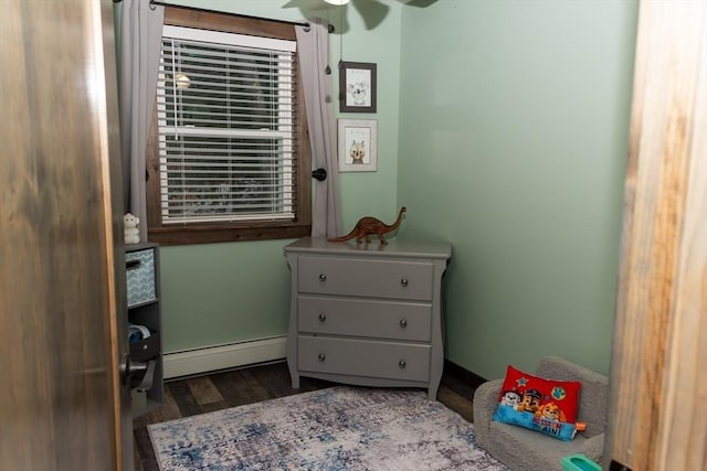 bedroom featuring ceiling fan, dark hardwood / wood-style floors, and a baseboard radiator