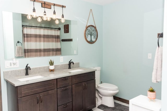 bathroom featuring toilet, tile patterned floors, vanity, and curtained shower