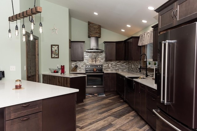 kitchen with appliances with stainless steel finishes, decorative backsplash, dark wood-type flooring, lofted ceiling, and wall chimney range hood