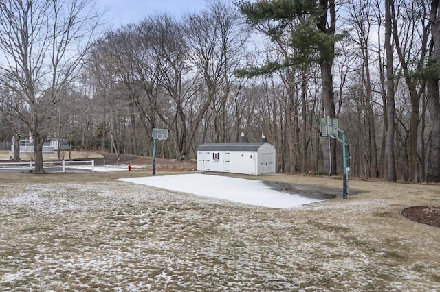 view of yard featuring a storage shed and basketball hoop