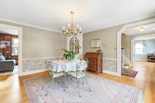 dining space featuring a chandelier, wood-type flooring, and ornamental molding