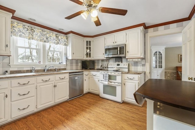 kitchen featuring white cabinets, stainless steel appliances, sink, light wood-type flooring, and crown molding