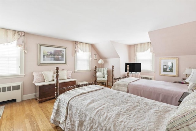 bedroom with multiple windows, radiator, and lofted ceiling