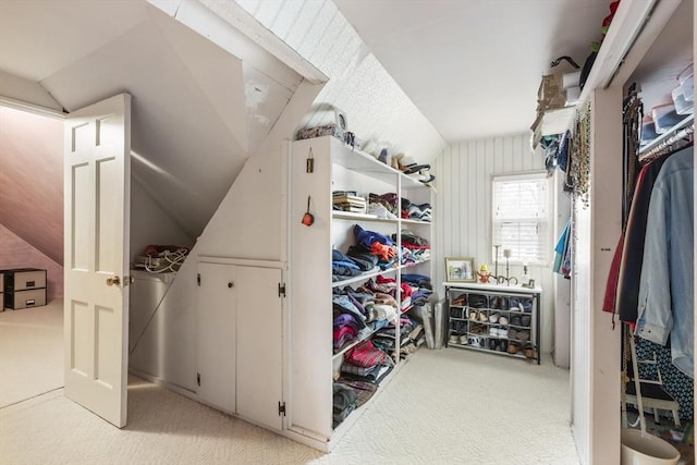 walk in closet with light carpet and vaulted ceiling