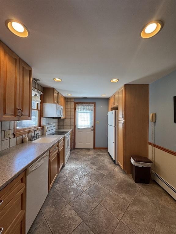 kitchen with backsplash, white appliances, brown cabinets, and a baseboard radiator