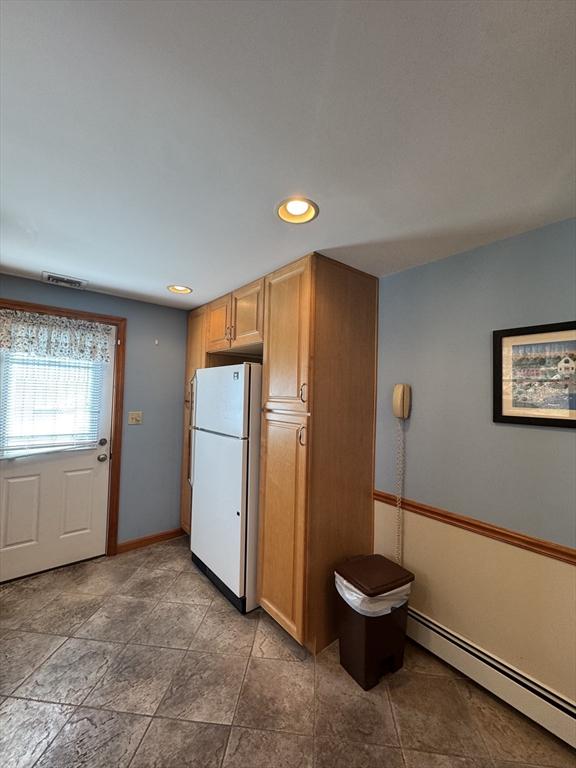 kitchen with visible vents, baseboards, recessed lighting, freestanding refrigerator, and a baseboard heating unit