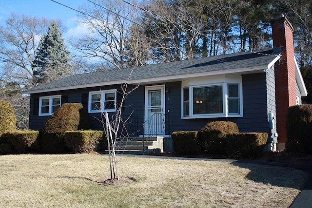 single story home featuring a front yard, roof with shingles, and a chimney