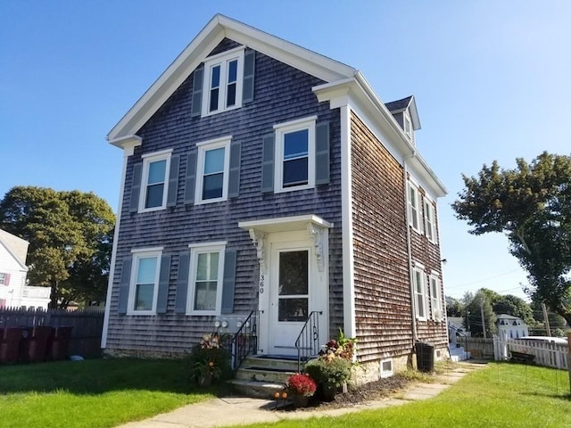 view of front of property featuring central AC and a front yard