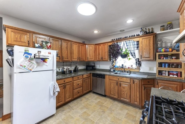 kitchen with gas range, white fridge, sink, and stainless steel dishwasher