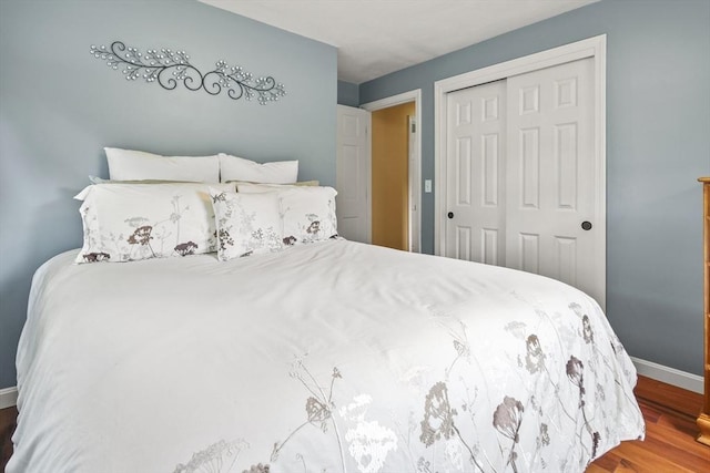 bedroom featuring a closet, wood finished floors, and baseboards