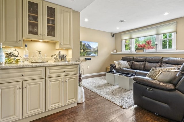 living room featuring bar with sink, dark wood-type flooring, baseboards, and recessed lighting