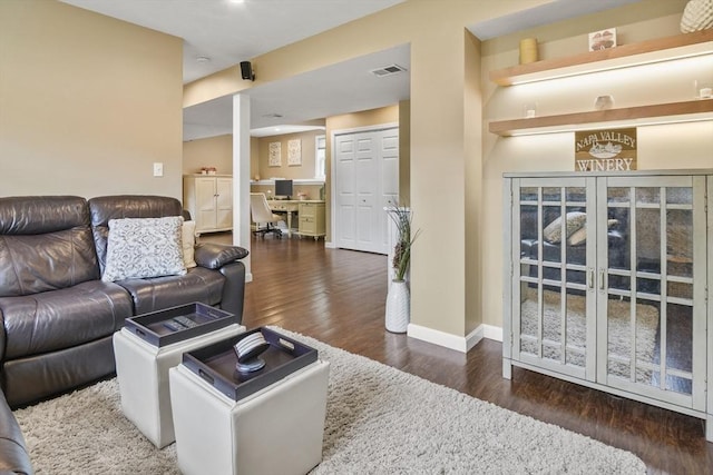 living area with wood finished floors, a desk, and baseboards