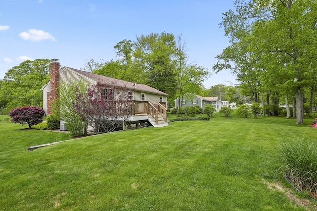 view of green lawn with a wooden deck