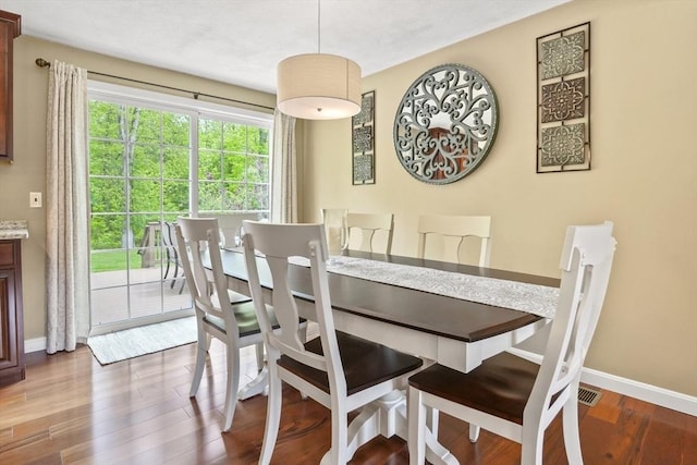 dining room with baseboards and wood finished floors