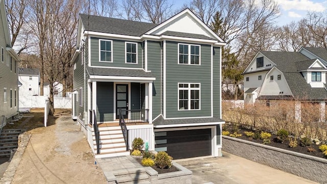 view of front facade with a shingled roof, concrete driveway, stairs, covered porch, and a garage