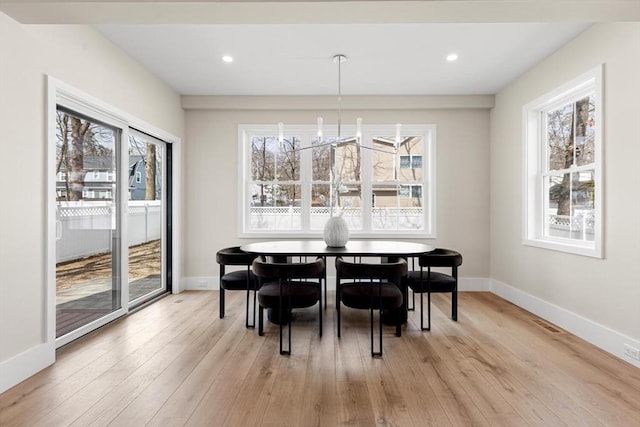 dining area featuring light wood-style flooring, baseboards, and a wealth of natural light