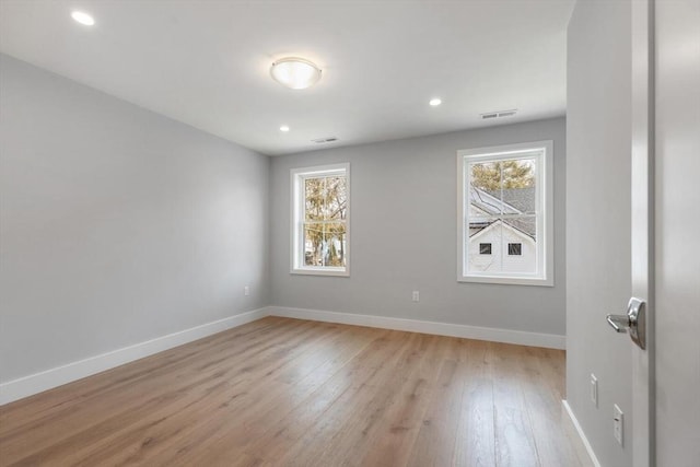 spare room with visible vents, a healthy amount of sunlight, light wood-style floors, and baseboards