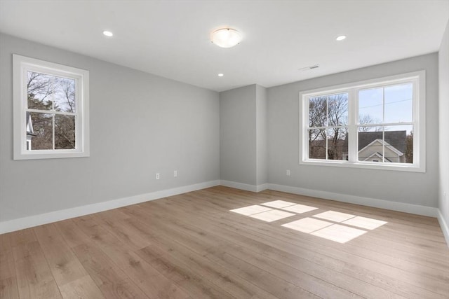 spare room with recessed lighting, baseboards, a healthy amount of sunlight, and light wood finished floors