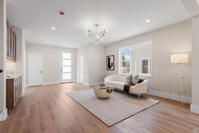 living area featuring light wood-style flooring, recessed lighting, baseboards, and a chandelier