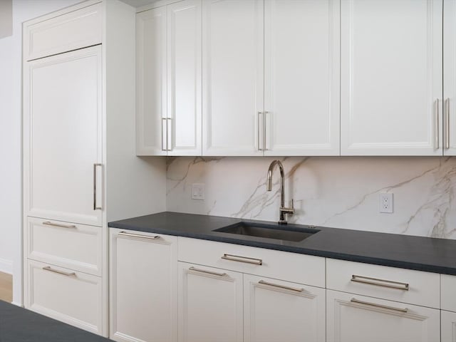 kitchen with white cabinets, tasteful backsplash, and sink