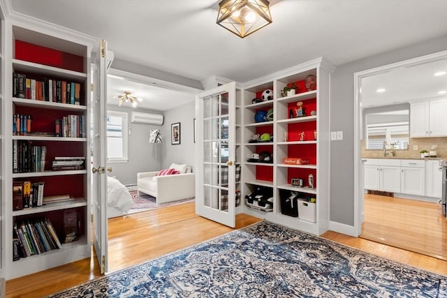 15 University Rd, Arlington, MA 02474 - living area with light wood-style floors, an AC wall unit, recessed lighting, and french doors